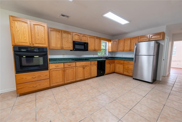 kitchen featuring sink, light tile patterned floors, and black appliances