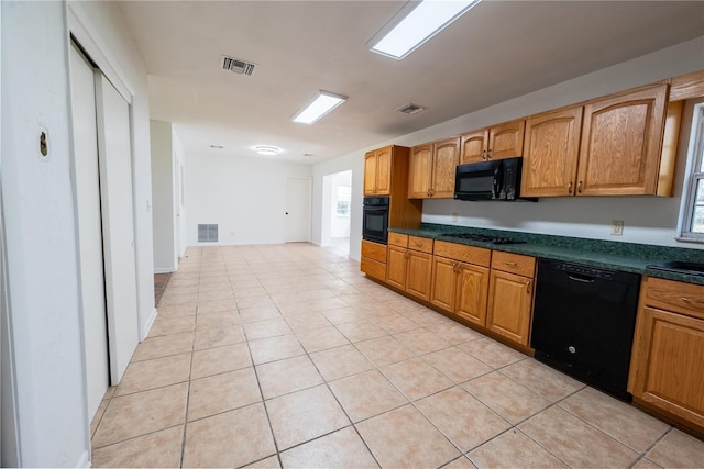 kitchen with light tile patterned flooring, sink, and black appliances