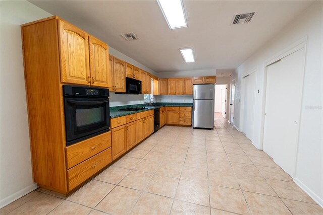 kitchen featuring black appliances and light tile patterned flooring