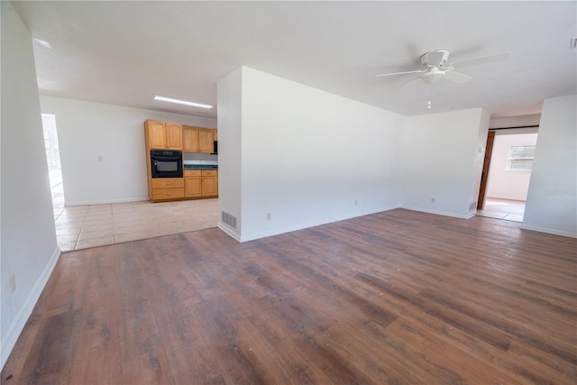 unfurnished living room with dark wood-type flooring and ceiling fan