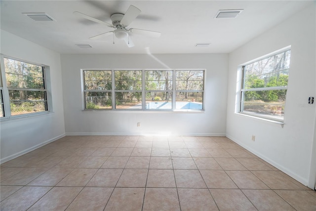 spare room featuring light tile patterned floors, a wealth of natural light, and ceiling fan