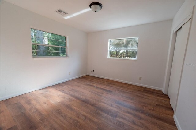 unfurnished bedroom featuring dark hardwood / wood-style floors and a closet