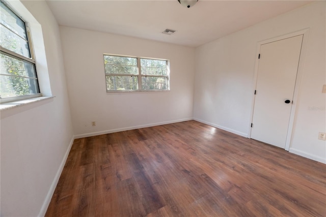 unfurnished room with dark hardwood / wood-style flooring