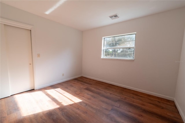 unfurnished room featuring dark hardwood / wood-style flooring