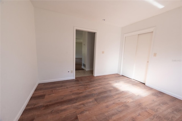 unfurnished bedroom featuring dark hardwood / wood-style flooring and a closet