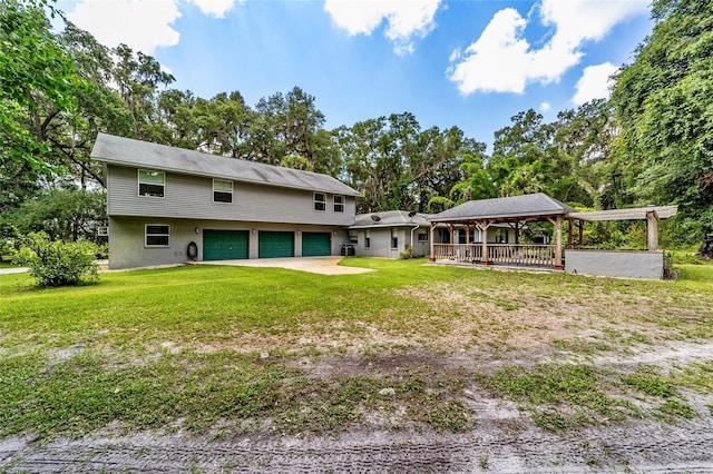 rear view of property with a yard and a garage