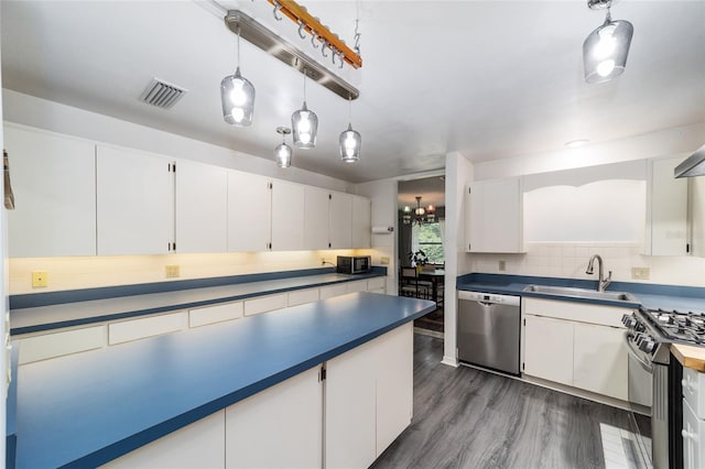 kitchen with white cabinetry, sink, stainless steel appliances, tasteful backsplash, and decorative light fixtures