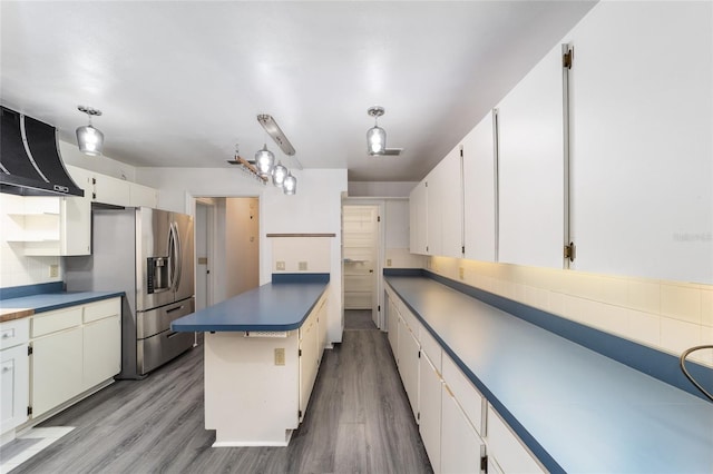 kitchen with stainless steel fridge with ice dispenser, white cabinets, hanging light fixtures, and light wood-type flooring