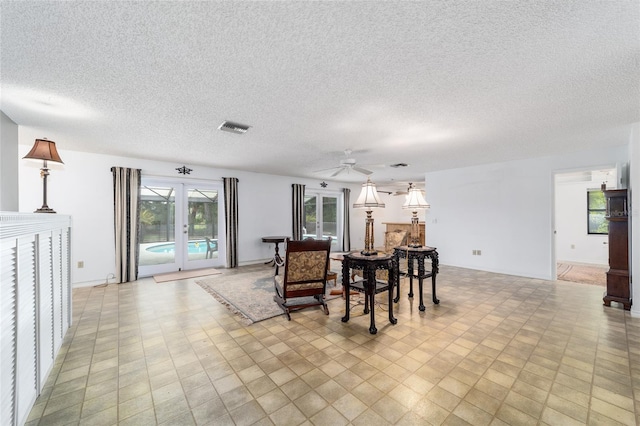 dining room featuring ceiling fan, a textured ceiling, and french doors