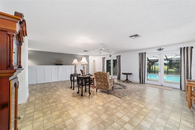 living room with a textured ceiling and ceiling fan