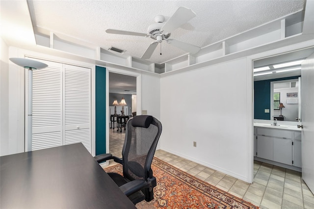 office featuring a textured ceiling, ceiling fan, and sink