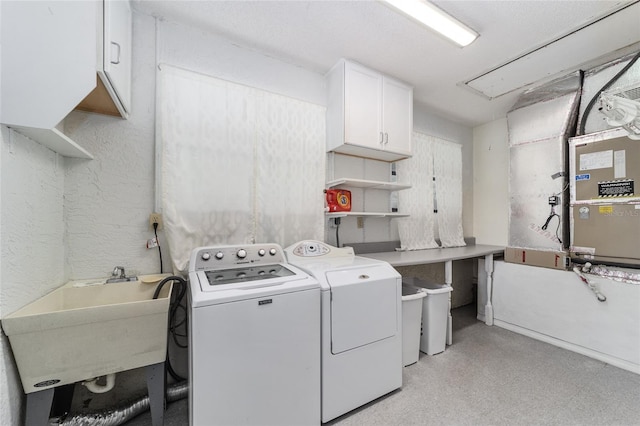 washroom with washing machine and clothes dryer, sink, and cabinets