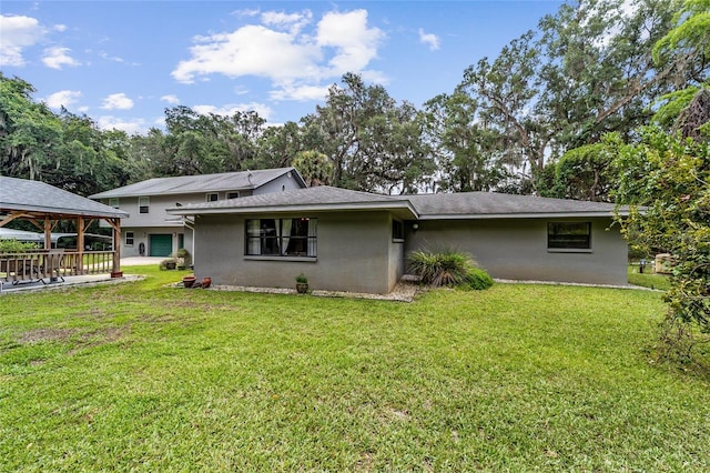 back of property featuring a gazebo and a lawn