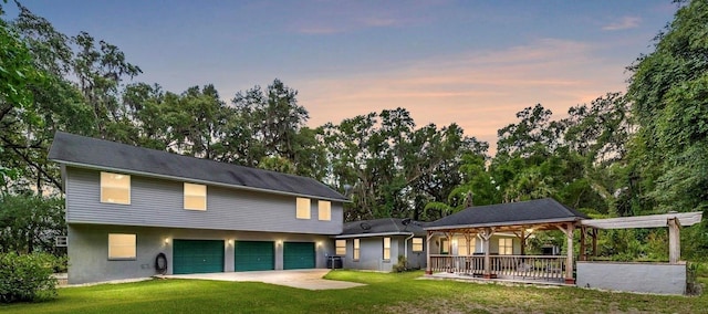 view of front of house featuring a lawn, cooling unit, and a garage