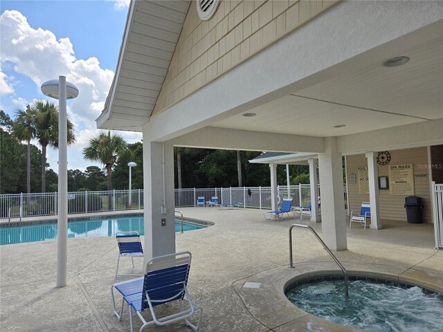 view of pool with a community hot tub and a patio area