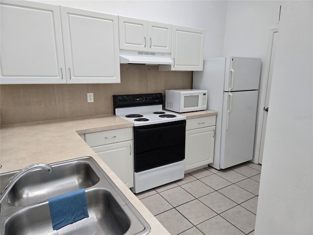 kitchen with sink, light tile patterned floors, white cabinets, and white appliances