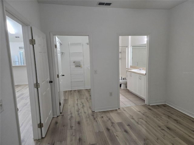 hallway with sink and light hardwood / wood-style flooring