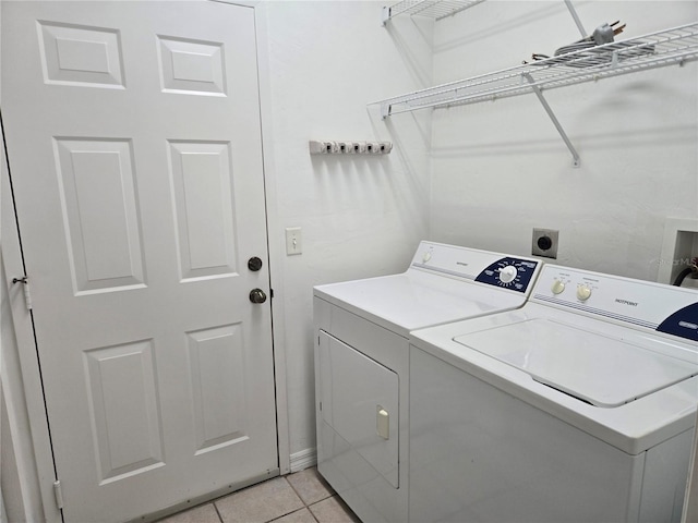 laundry room with washing machine and dryer and light tile patterned flooring