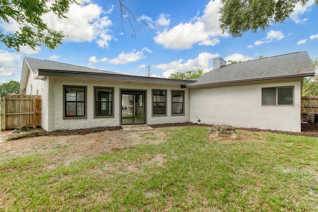 rear view of property featuring a yard