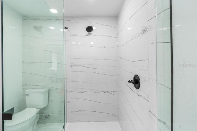 bathroom with tiled shower and toilet