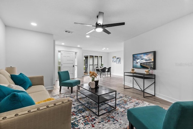 living room with hardwood / wood-style floors and ceiling fan