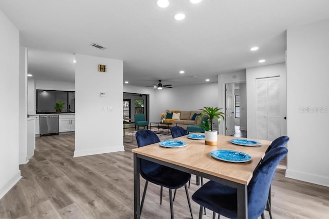 dining area with ceiling fan and light hardwood / wood-style flooring