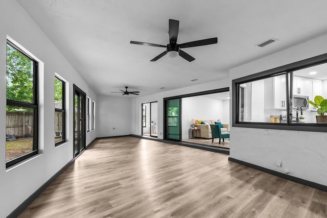 unfurnished living room with hardwood / wood-style floors and a healthy amount of sunlight