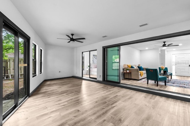 living room featuring light hardwood / wood-style flooring and ceiling fan