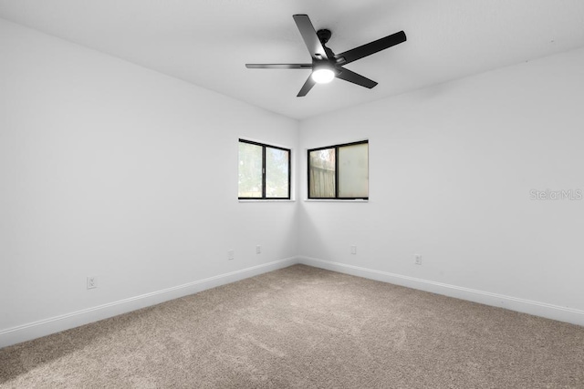 empty room with ceiling fan and carpet