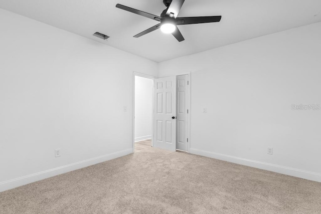 carpeted spare room featuring ceiling fan