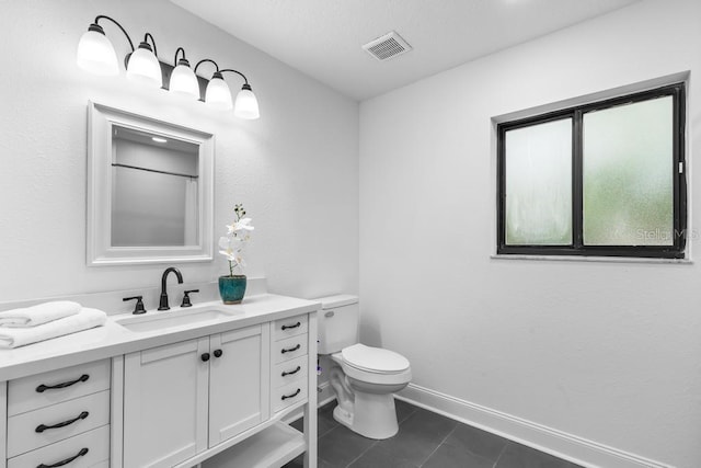 bathroom featuring vanity, tile patterned floors, and toilet