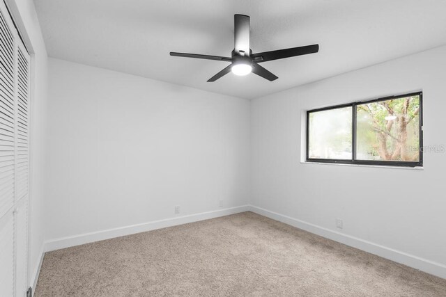 carpeted empty room featuring ceiling fan