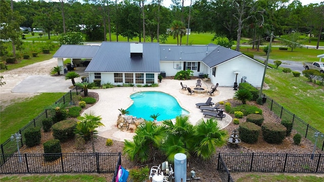 view of pool featuring a sunroom, a lawn, a patio area, and an outdoor fire pit