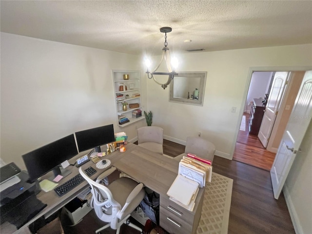 office space featuring an inviting chandelier, dark wood-type flooring, and a textured ceiling