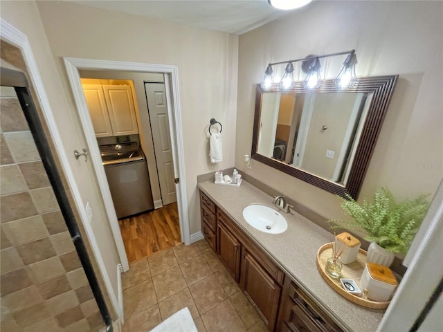 bathroom featuring vanity, washer / dryer, and tile patterned floors