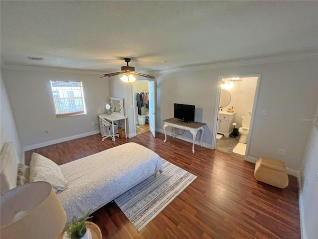 bedroom featuring dark wood-type flooring, ornamental molding, a spacious closet, and a closet