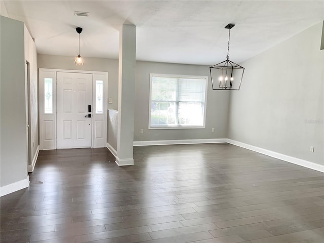 foyer entrance with a chandelier and dark hardwood / wood-style floors