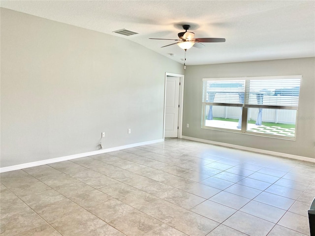 spare room with light tile patterned flooring, a textured ceiling, vaulted ceiling, and ceiling fan