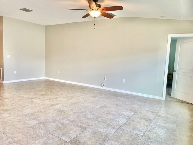 tiled empty room with ceiling fan and lofted ceiling