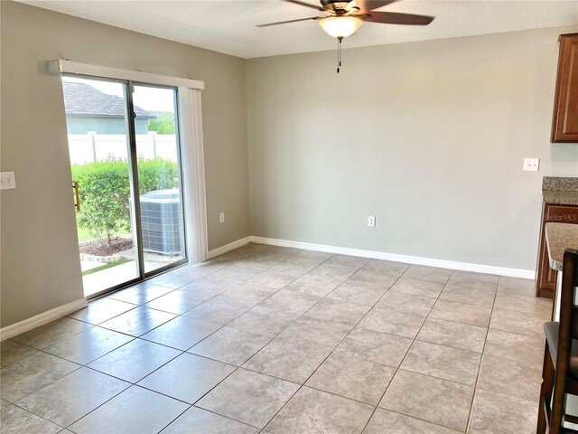 interior space with light tile patterned floors and ceiling fan