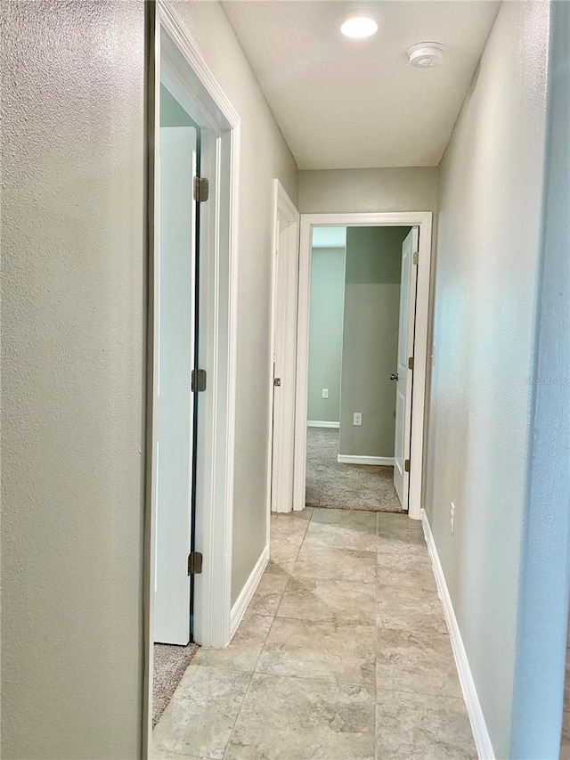 hall with light tile patterned floors