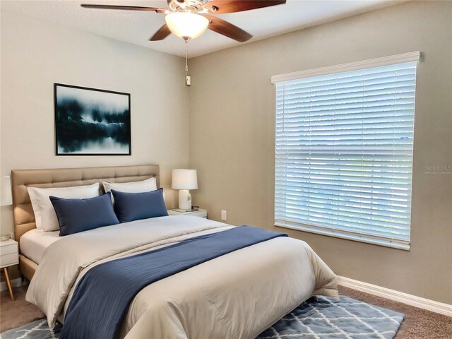 bedroom with multiple windows, carpet, and ceiling fan