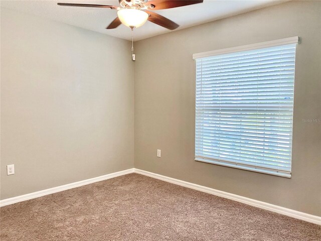 empty room with carpet flooring, ceiling fan, and plenty of natural light