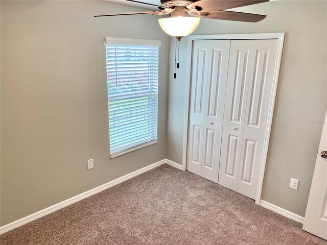 unfurnished bedroom with carpet flooring, a closet, and ceiling fan