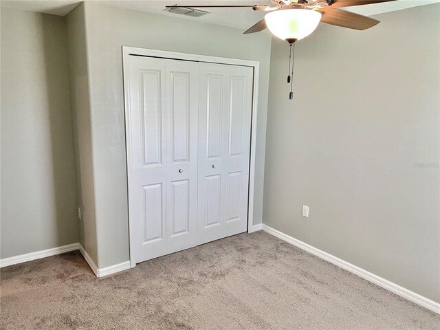 unfurnished bedroom featuring carpet flooring, a closet, and ceiling fan