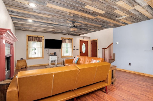 living room featuring ceiling fan, hardwood / wood-style floors, wood ceiling, and a fireplace