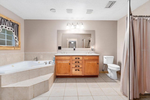 bathroom with toilet, vanity, tile patterned flooring, a textured ceiling, and a relaxing tiled tub