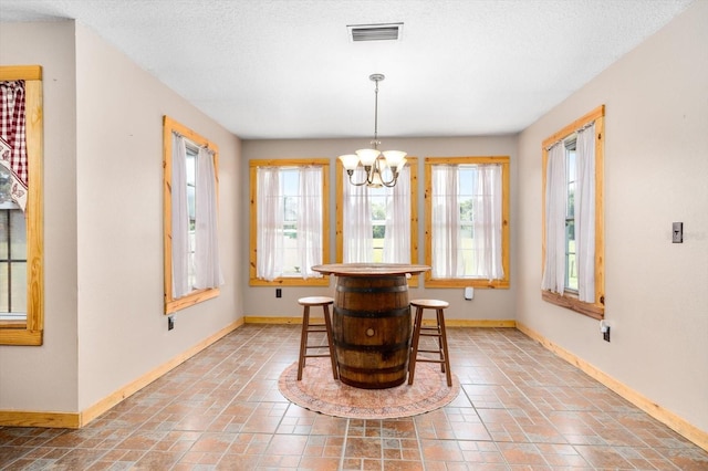 dining room featuring a textured ceiling and an inviting chandelier