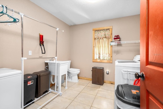 bathroom featuring toilet, tile patterned floors, and washing machine and clothes dryer