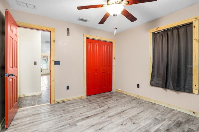 unfurnished bedroom with ceiling fan, a closet, and light hardwood / wood-style flooring